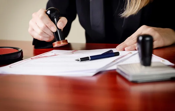 Closeup on notary's public hands stamping document. — Stock Photo, Image