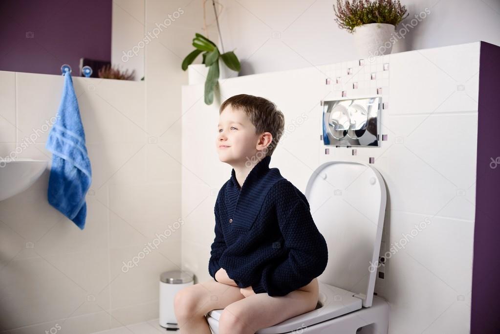 Happy smiling 6 year old boy on the toilet. Stock Photo by 96283962