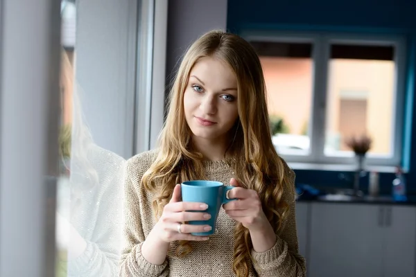 Blondýnka pití kávy z hrnečku — Stock fotografie