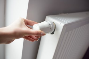 Tatlı kadın yandan sıcaklık termostat tarafından ayarlama