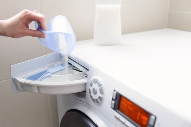 Portre üzerinde deterjan çamaşır makinesi dökme kadın eli