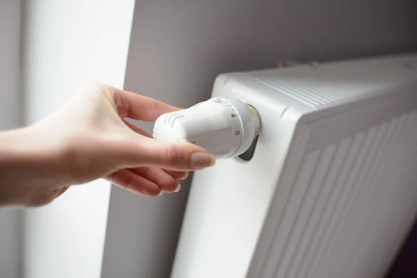 Primer plano en la mano de la mujer que ajusta la temperatura por termostato — Foto de Stock