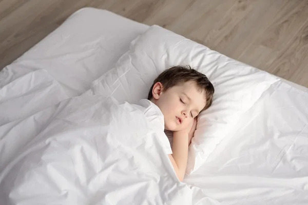 Tired little boy sleeping in bed, happy bedtime in white bedroom — Stock Photo, Image