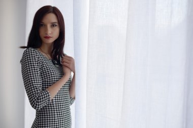 Genç resmen pencerenin önünde duran kadın giyinmiş. 