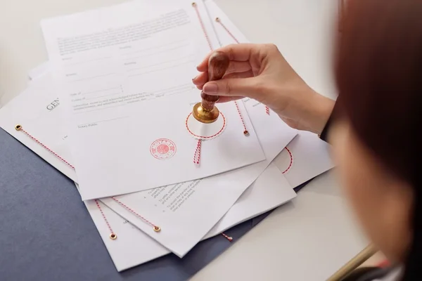 Close-up on notaries public hand stamping document — Stock Photo, Image