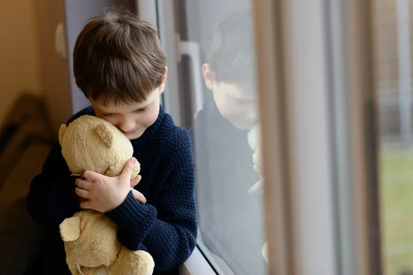 Triste garçon étreint son ours en peluche . — Photo