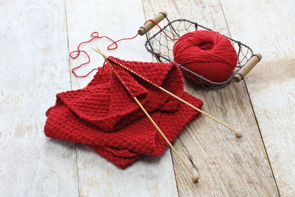 Hand knitted red scarf, yarn ball and knitting needles — Stock Photo, Image