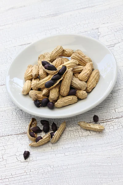 Amendoins pretos no prato branco — Fotografia de Stock