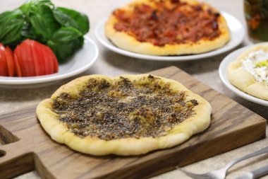 Manakeesh, Lübnan pizzası, üstüne zaatar (kekik), labirent (süzme yoğurt) ve sığır eti.