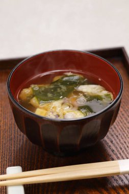 Japon miso çorbası, yeşil soğan, wakame yosunu ve kızarmış tofu gibi ek malzemeler..