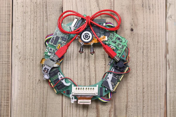 Geeky christmas wreath made by old computer parts hanging on wooden door — Stock Photo, Image