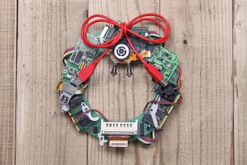 Geeky christmas wreath made by old computer parts hanging on wooden door  Stock Photo by ©asimojet 60463179