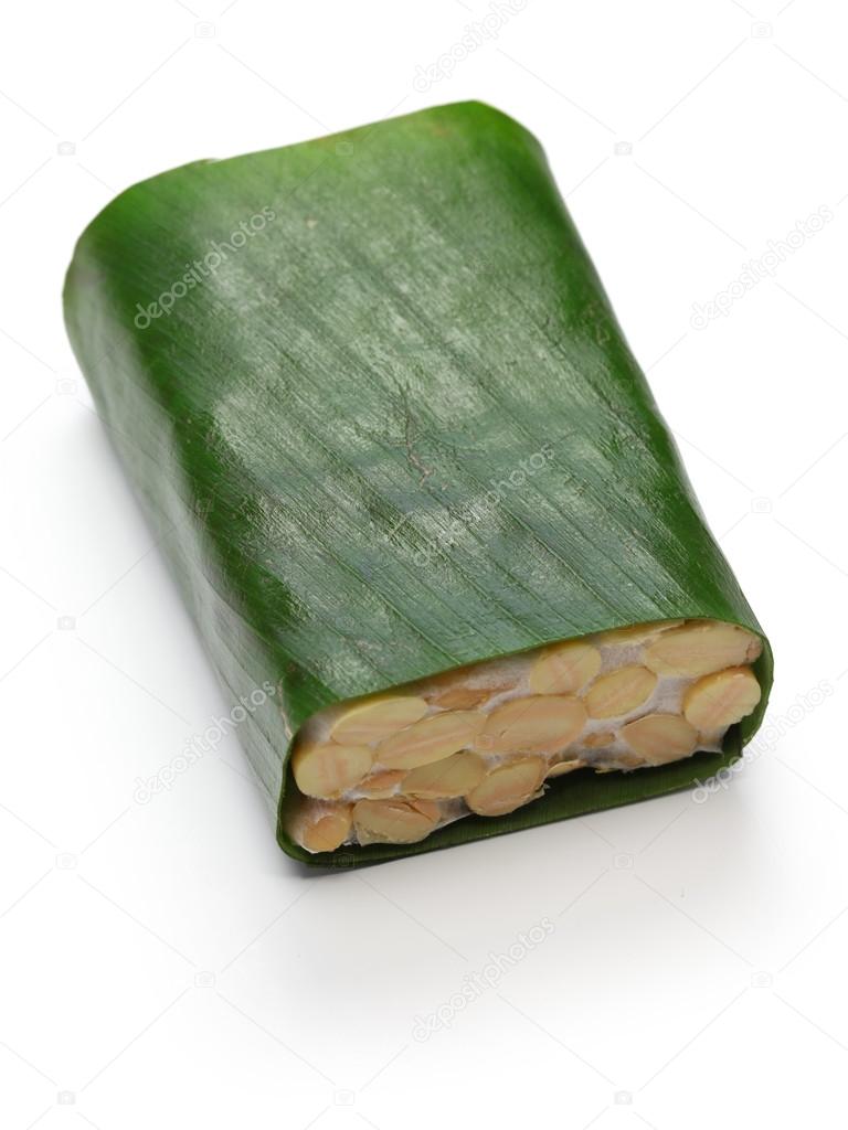 Fresh tempeh is wrapped in banana leaf