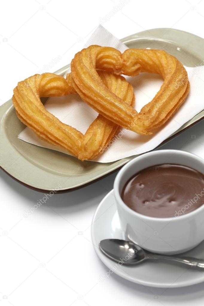 Heart shape churros and hot chocolate on white background