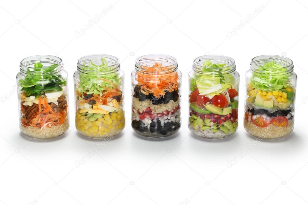 Vegetable salad in glass jar, no lid, white background