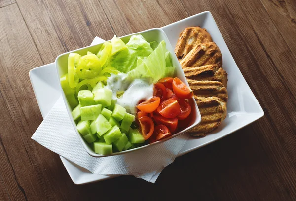 Frischer Salat mit Tomaten und Soße und Brot — Stockfoto