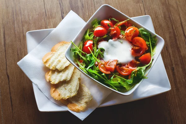 Frischer Salat mit Tomaten und Soße und Brot — Stockfoto