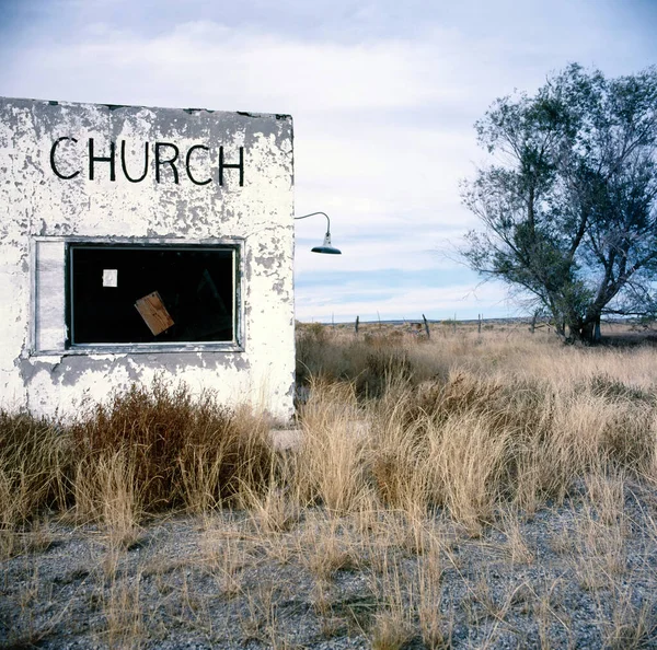 An abandoned rural church wall with sign Church on it
