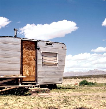 Çölde çürümeye bırakılmış eski püskü yıpranmış karavan. 