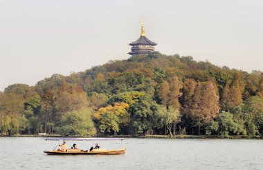 HANGZHOU, ÇİN - 25 Kasım 2008: Arka planda bir pagoda ile batı gölünde turist botu