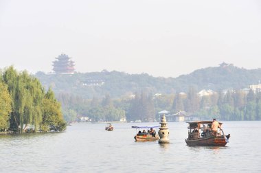 HANGZHOU, ÇİN - 25 Kasım 2008: Arka planda bir pagoda ile batı gölünde turist botları