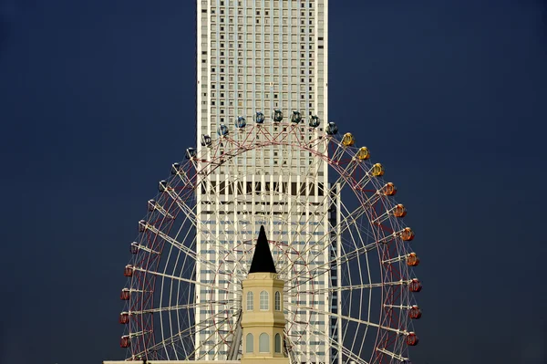 Sky scraper and ferris wheel — Stock Photo, Image