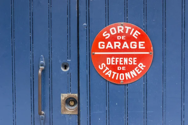 Blue wooden door with No parking sing in french. — Stock Photo, Image