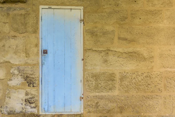 Weathered wooden door with blue paint chipped and peeling. — Stock Photo, Image