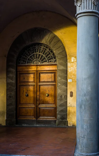 Zabytkowe drewniane drzwi przy ulicy Pisa. Toskania, Włochy. — Zdjęcie stockowe