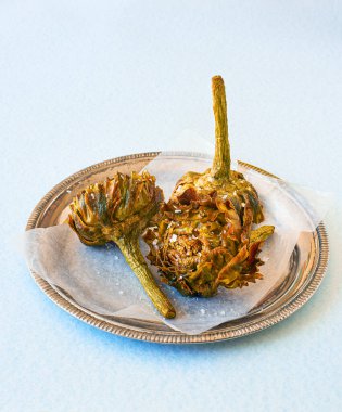 Roman fried artichokes Jewish style seasoned with flakes of kosher salt. Italian cuisine. clipart