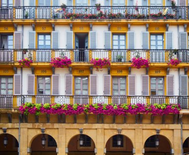 Anayasa Meydanı 'nın (Plaza de la Constitucion) numaralı balkonları. Tarihsel olarak meydan, boğa güreşi festivallerine ve balkonlara kiralık kutular olarak numaralandırıldı ve koridoru izledi. San Sebastian, Bask Bölgesi, Guipuzcoa. İspanya