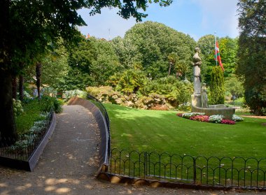 Plaza de Guipuzcoa Meydanı 'ndaki Jose Maria Usandizaga anıtı arka planda Bask Ülkesi bayrağı. San Sebastian, Gipuzkoa, İspanya.