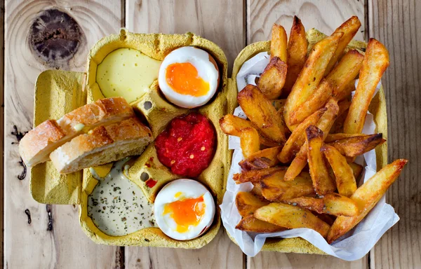 Two soft boiled eggs with fries and sauces. — Stock Photo, Image