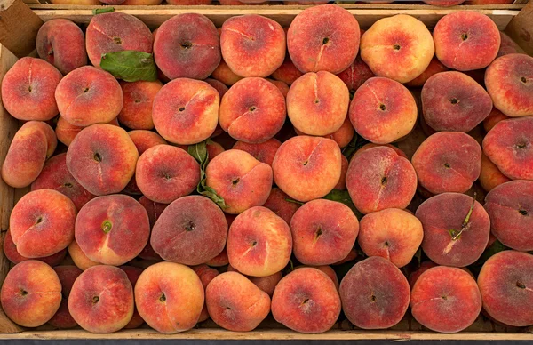 Fresh saturn peaches in a market. — Stock Photo, Image
