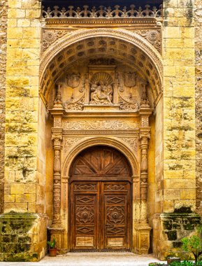 Guadalajara, İspanya - 18 Nisan 2025. İspanya 'nın Guadalajara şehrindeki Convento de la Piedad' ın Plateresk girişi. Ayrıntılı taş oymalar, dini yardım ve Rönesans Sarayı 'nın tarihi ahşap kapısı ve eski manastır..