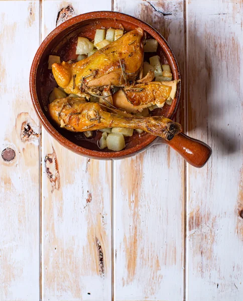 Gegrilde kip met aardappelen in een rustieke kom. Typische Spaanse tapa. — Stockfoto