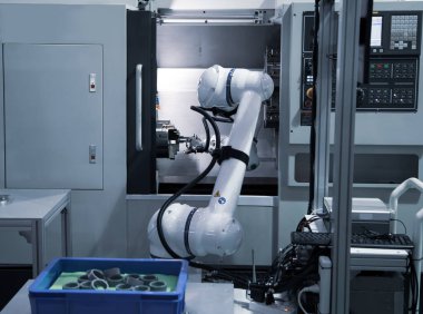 Metal parçaları CNC makinesine yükleyen otomatik endüstriyel robot. Endüstriyel üretim