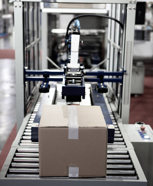 Картон на роликовом конвейере. Автоматическая упаковочная машина. Склад промышленной логистики