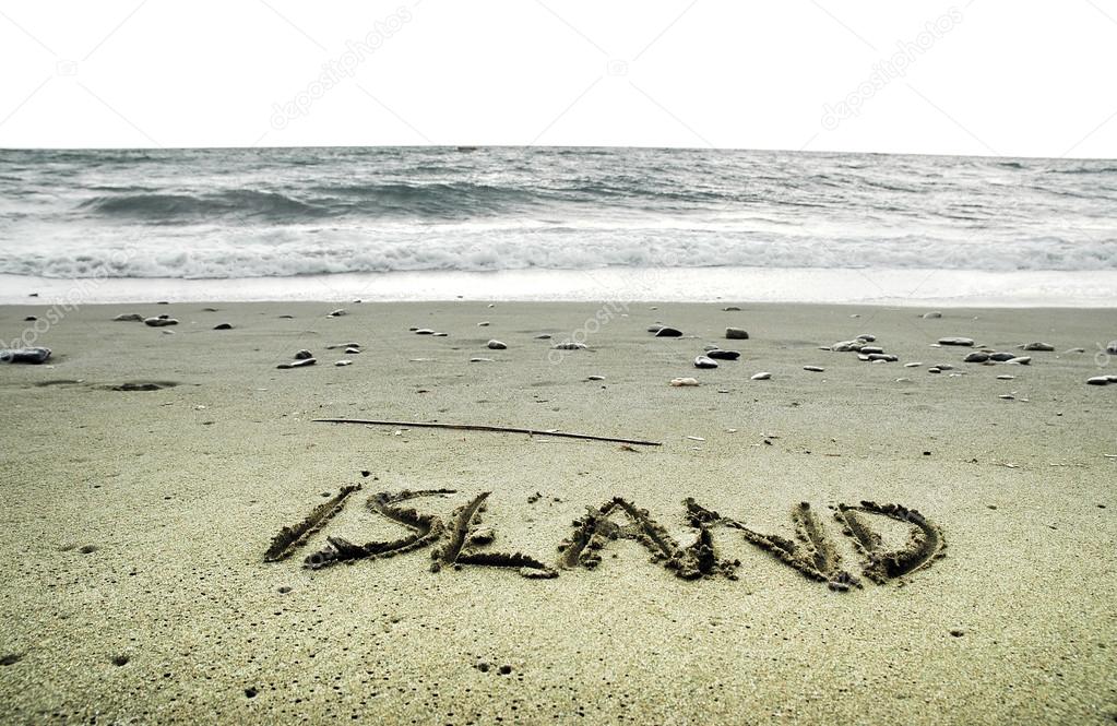 Island written in sand on the beach