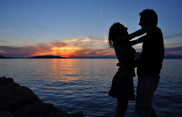 Zee zonsondergang met silhouet van een romantisch paar — Stockfoto