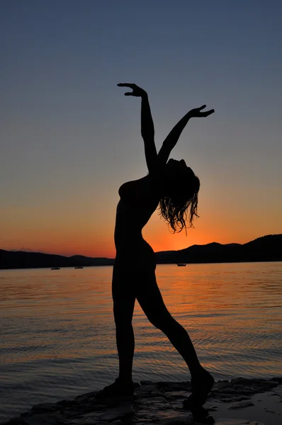 Silhouette of a sexy woman in sunset on the beach — Stock Photo, Image