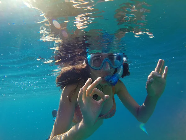 Vista submarina de una mujer haciendo snorkel en el mar tropical — Foto de Stock