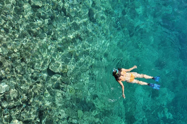 Mujer joven en traje de baño haciendo snorkel en un mar tropical poco profundo —  Fotos de Stock