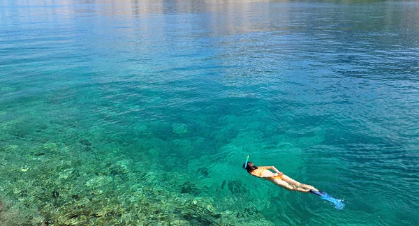Jovem mulher snorkeling no mar raso transparente — Fotografia de Stock