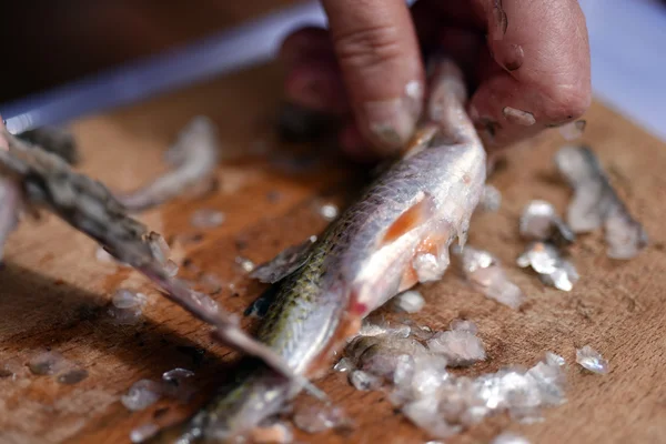 Visser een vis schoonmaken voor diner — Stockfoto