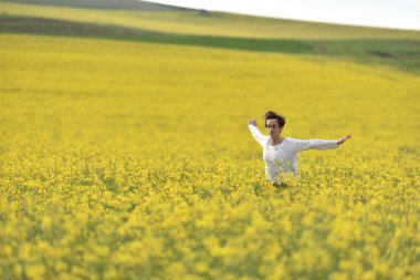 Hippi kız bir kanola alanda yürüyüş. Özgürlük kavramı