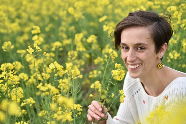 Jovem sentindo-se feliz no meio de um campo de canola — Fotografia de Stock