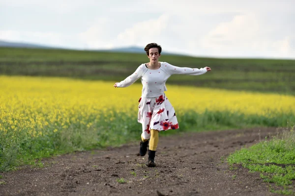 Jonge vrouw draait op een weg van het platteland. Concept van de vrijheid — Stockfoto