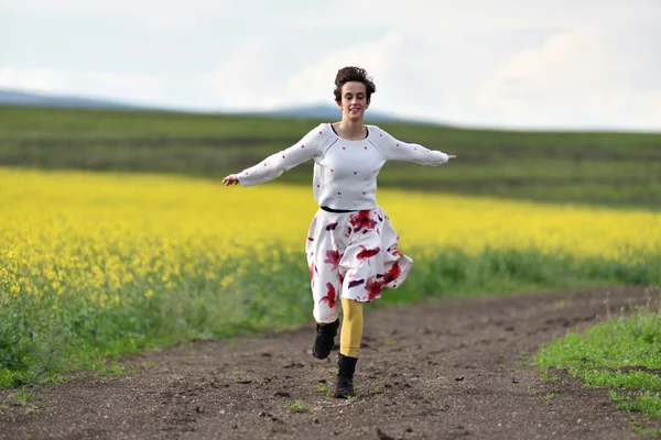 Bir kırsal yolda çalışan genç kadın. Özgürlük kavramı — Stok fotoğraf