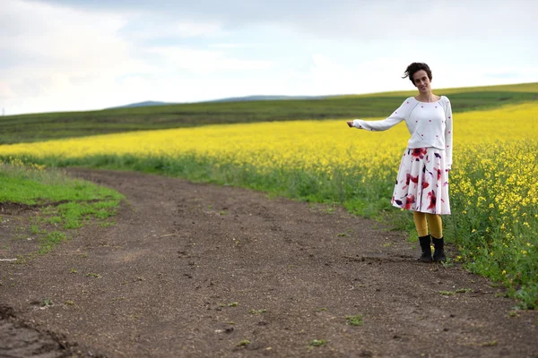 Viajero mujer en vestido autostop en el campo —  Fotos de Stock